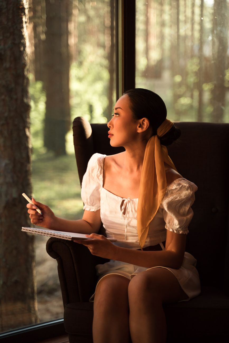 Travel writer reviewing notes beside open window