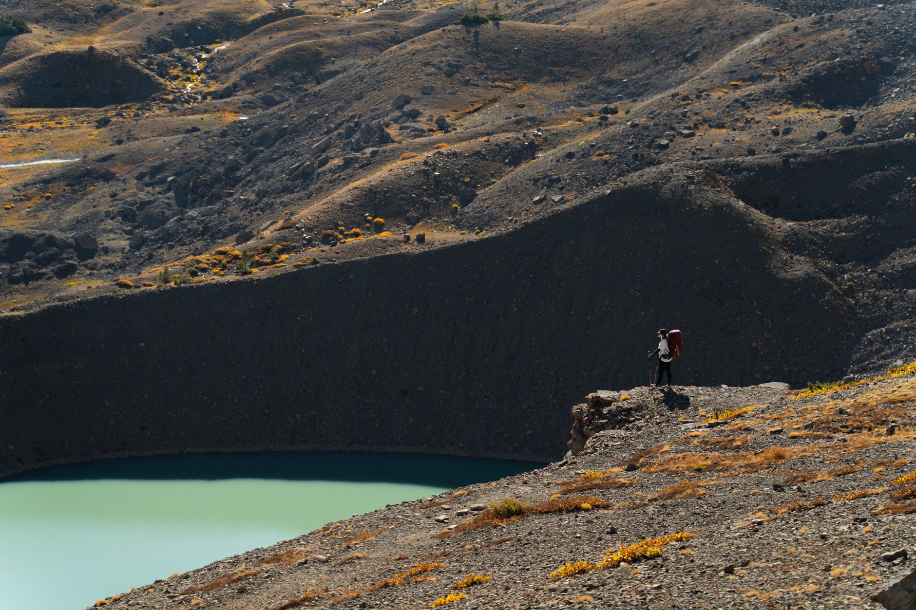 Hiker crossing remote alpine meadow